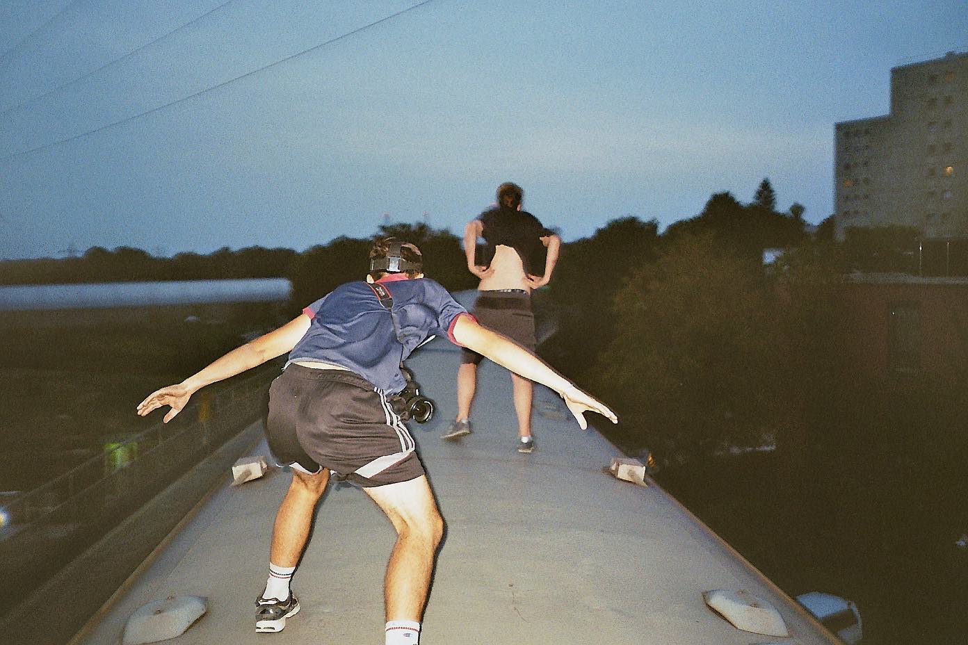 Men surfing on top of train in Europe.