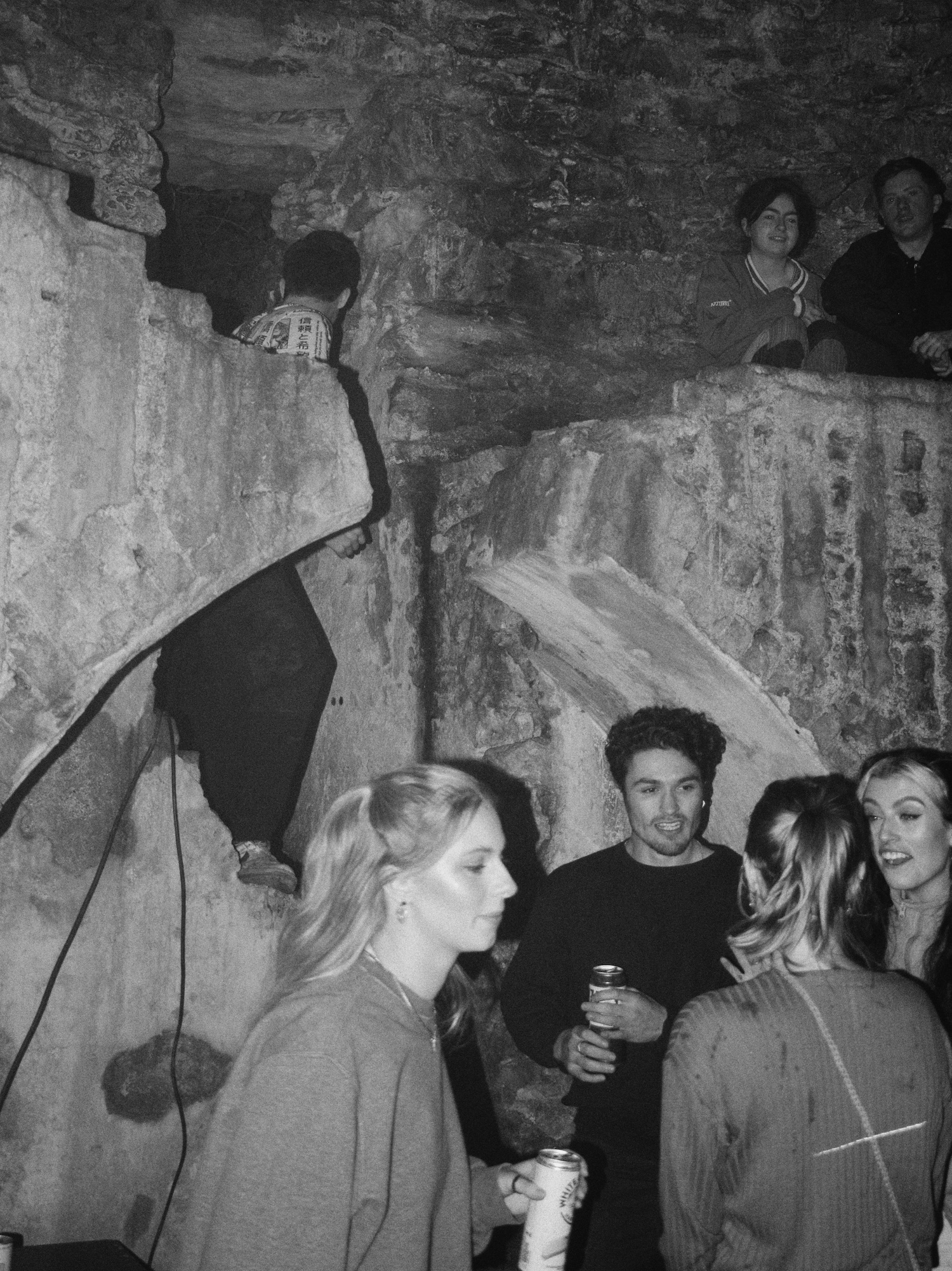 young people are gathered at party inside the ruins of a castle