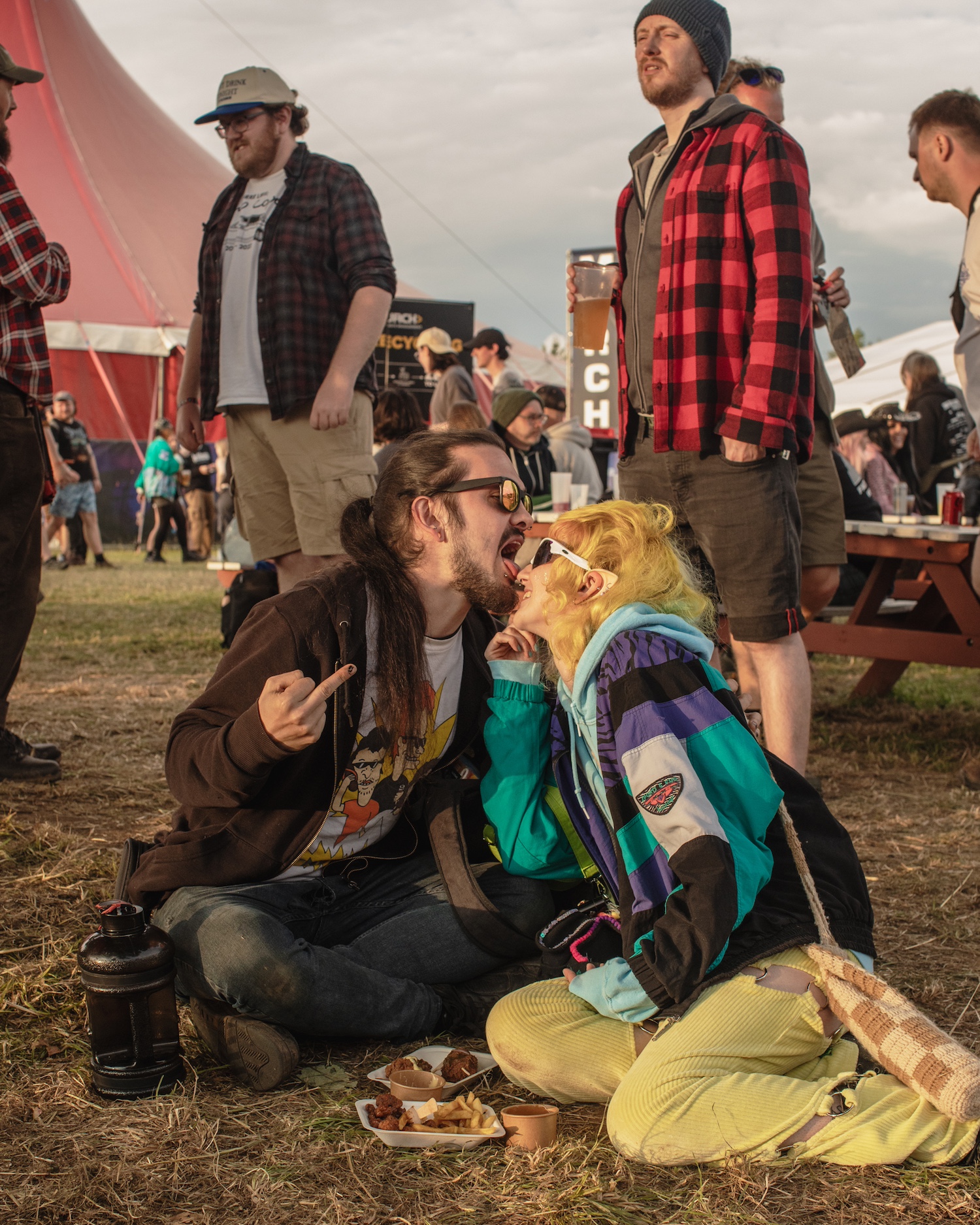 Two people sat on the floor and licking each other's faces