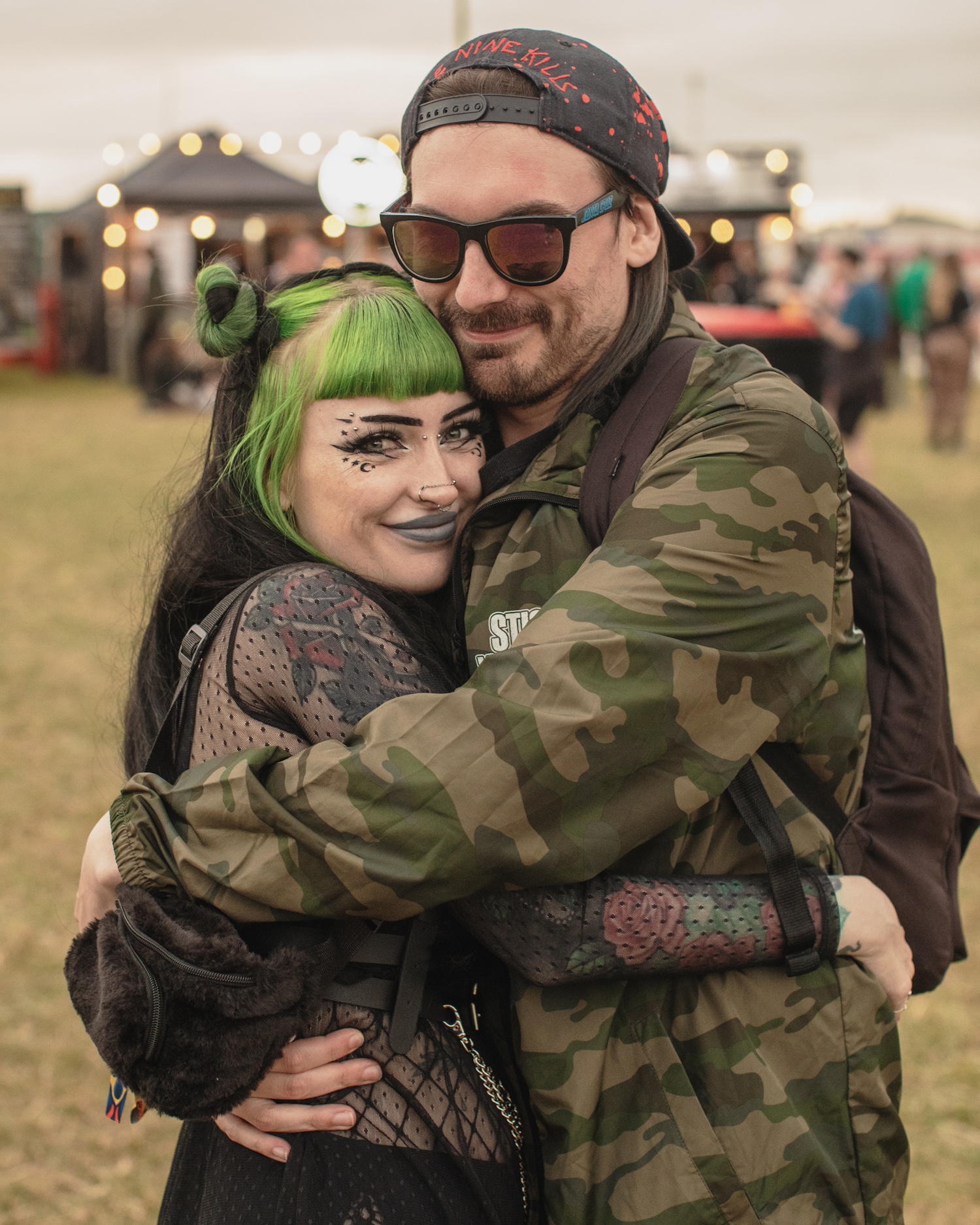 Two people hugging in a field at a music festival