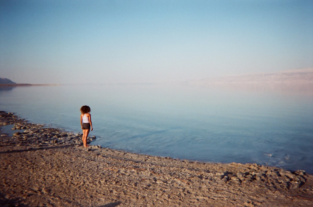 woman standing next to still water