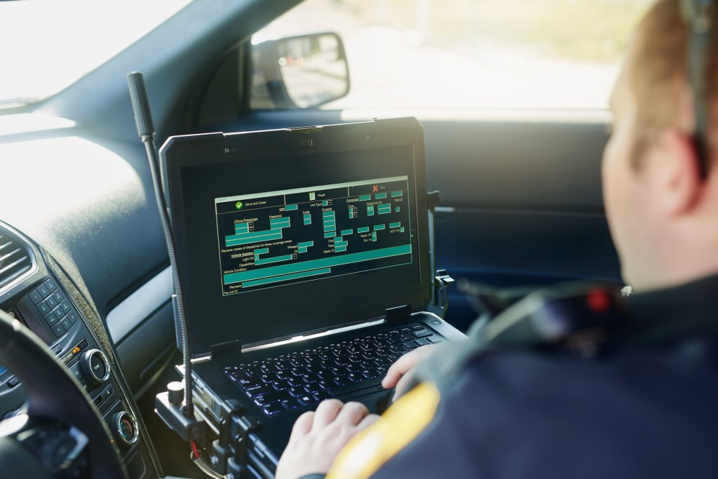 Database, laptop and a police officer in a car for security, urban law and safety data while working. Screen, programming and male protection professional with a computer to hack system in transport; Shutterstock ID 2304125381; purchase_order: vice.com; job: ; client: ; other: