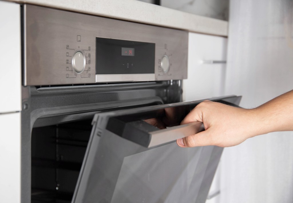 Black modern electric oven in white kitchen with thermo grill and convection function.