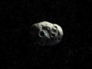 Rocky asteroid with impact craters isolated on a dark background. The space rock is approaching Earth. observation of celestial bodies