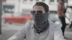 A male crack cocaine user poses in Düsseldorf, Germany, wearing a face covering snood and sunglasses