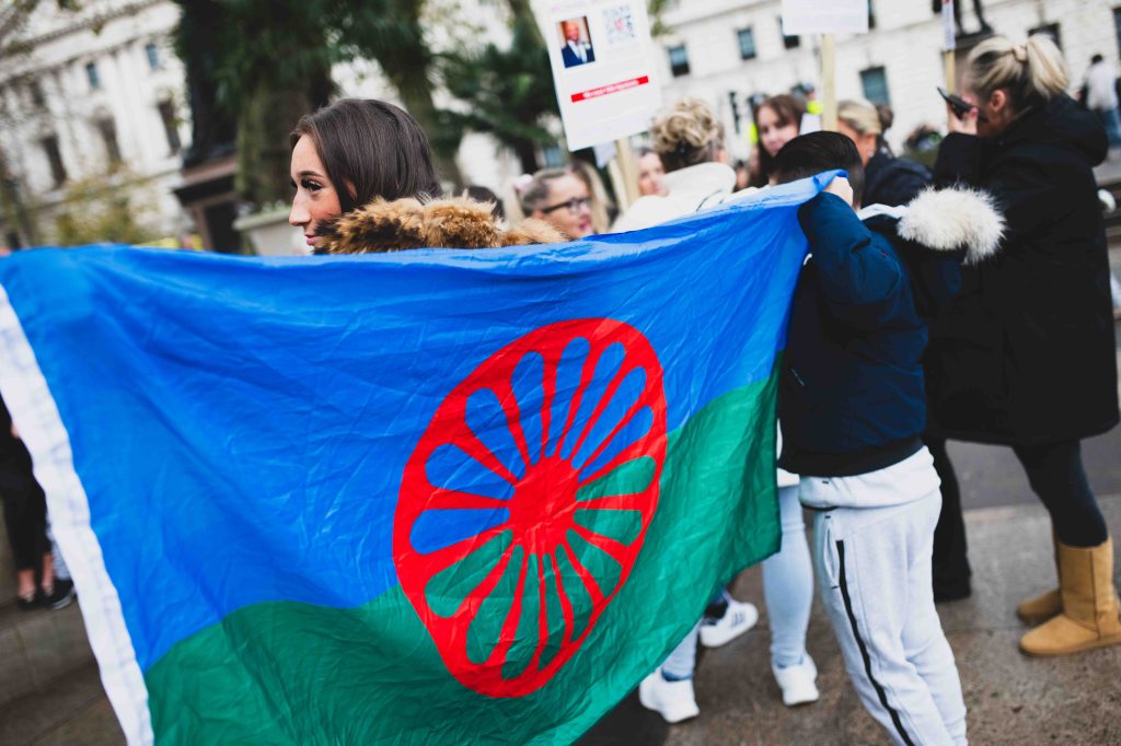 A female protester holds up the Romani flag at a demonstration pushing for greater respect for the UK's Gypsy, Roma and Traveller communities, in central London in November 2024