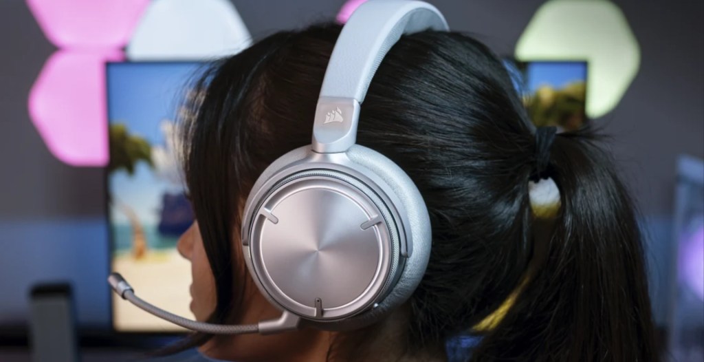 A female model wearing the white variation of the Corsair Virtuoso Max headset